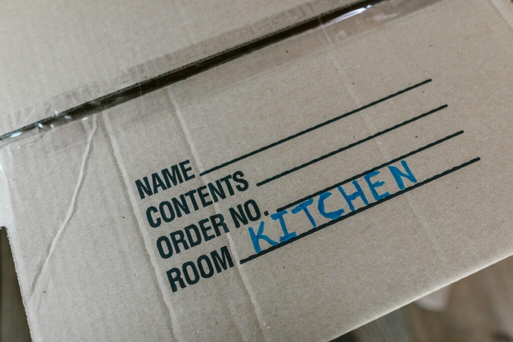 Cardboard moving box labeled Kitchen during senior downsizing move