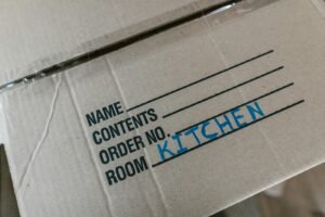 Cardboard moving box labeled Kitchen during senior downsizing move