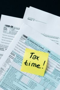 Senior tax return documents IRS Form 1040 and 1040 SR with Tax time note highlighting fraud awareness for older adults